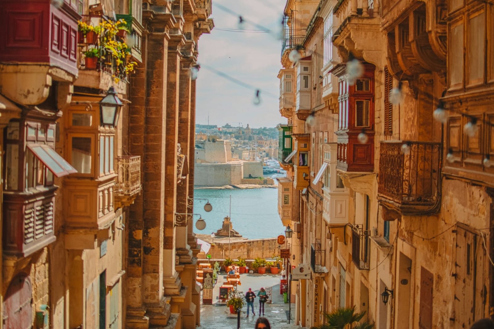 Narrow street in Valletta with traditional wooden balconies overlooking the Grand Harbour